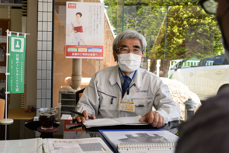 資料を広げて相談に応じる石のサンポウのスタッフ